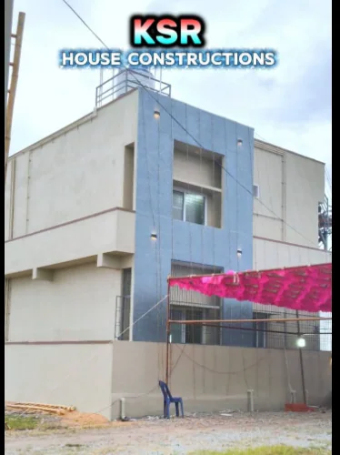 Narrow white two-level house with a full-height blue entrance frame.