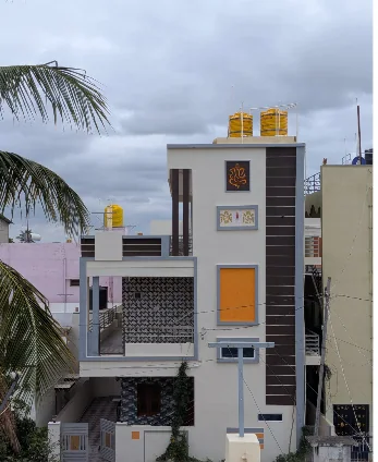 Narrow multi-level home with a dark vertical feature wall, white balconies and orange accents.